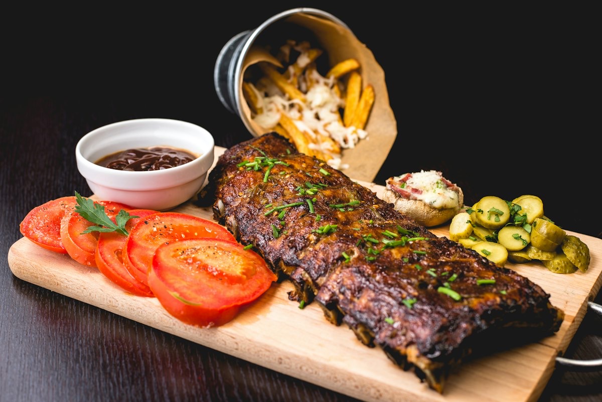 Wood-fired ribs with tomatoes and fries at Ember & Palm